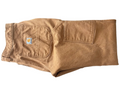 Folded brown pants with a brand logo on a dark surface